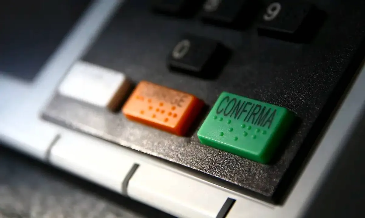 Mãos analisando gráfico financeiro em tablet com elementos políticos ao fundo