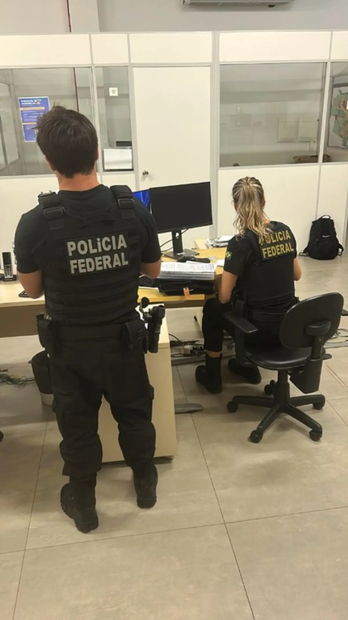 Agentes da Polícia Federal durante a Operação Lamaçal, com documentos e veículos apreendidos ao fundo