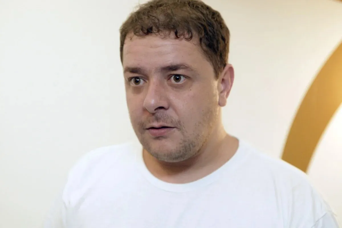 Documentos sigilosos sendo examinados em uma mesa de vidro, com partes censuradas, e a silhueta de uma pessoa ao fundo, representando a quebra de sigilo e investigação.