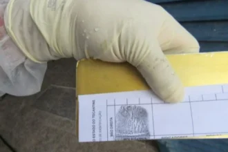 Cientista forense analisando impressões digitais recuperadas de vítima de acidente