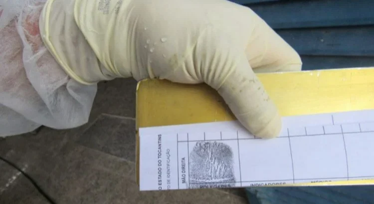 Cientista forense analisando impressões digitais recuperadas de vítima de acidente