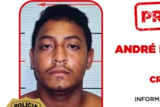 Bota de policial em solo árido, com cápsula de bala e luzes da PM ao fundo, após confronto no Tocantins.