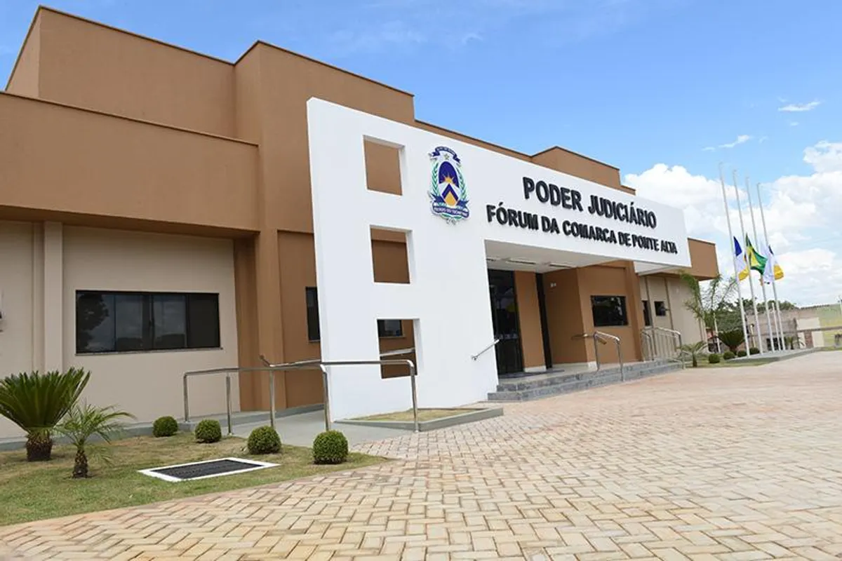 Par de sapatos femininos gastos em rua de terra batida em cidade pequena, simbolizando feminicídios e a ausência de proteção em municípios remotos.