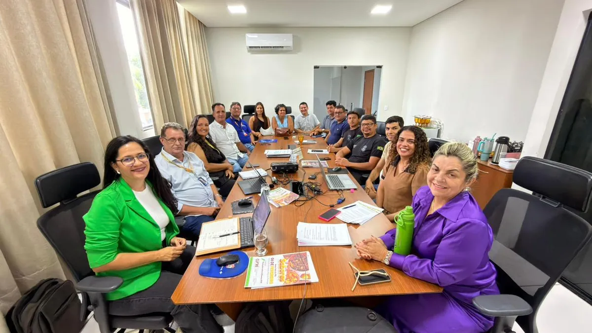 Equipe do Sebrae avaliando produtos da Feira de Sabores em Guaraí, com feirante sorridente.