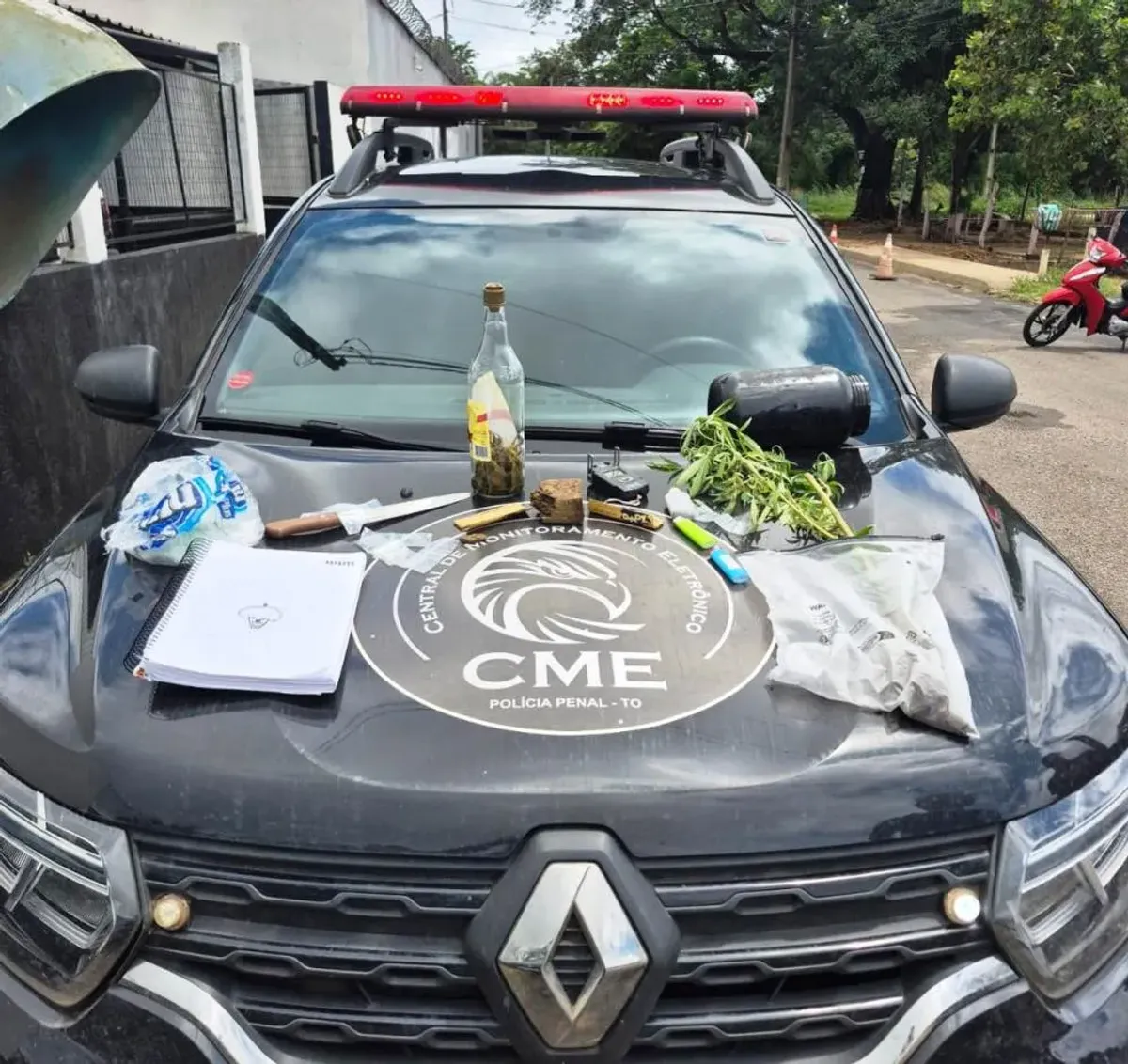Evidências de tráfico de drogas, incluindo porções de entorpecentes e balança de precisão, sendo examinadas por agente da Polícia Penal após prisão em Tocantínia.