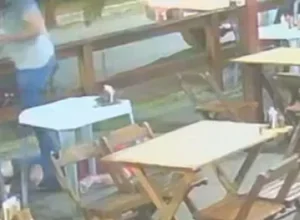 Policiais civis em operação noturna, com viaturas e luzes de emergência ao fundo, simbolizando a ação integrada entre estados.