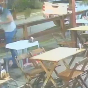 Policiais civis em operação noturna, com viaturas e luzes de emergência ao fundo, simbolizando a ação integrada entre estados.