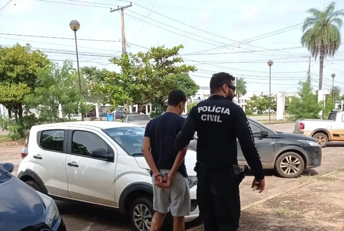 Distintivo da Polícia Civil do Tocantins em uma mesa, com dispositivos eletrônicos desfocados ao fundo, simbolizando a Operação Custos contra crimes cibernéticos.
