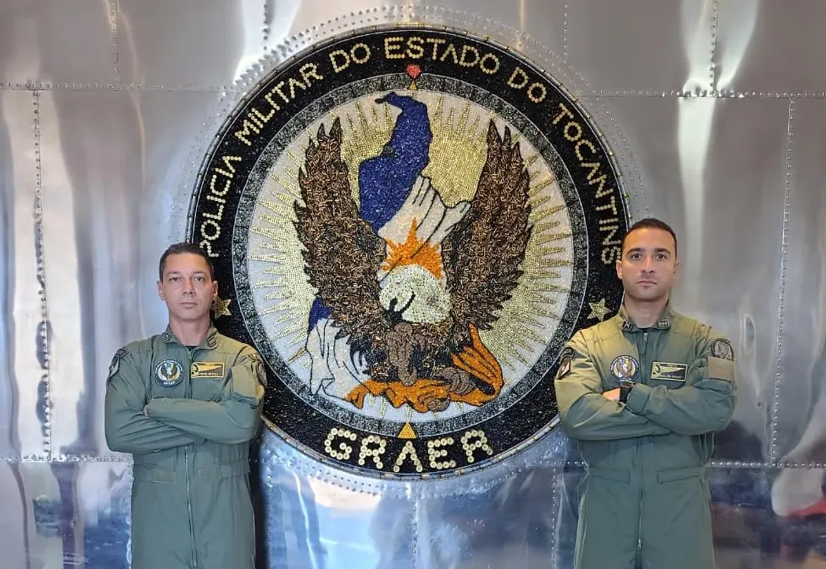 Tenente-coronel Dennys Dalla e Major Wesley Guimarães, novos comandantes do GRAER/PMTO, em frente a um helicóptero policial no Tocantins.