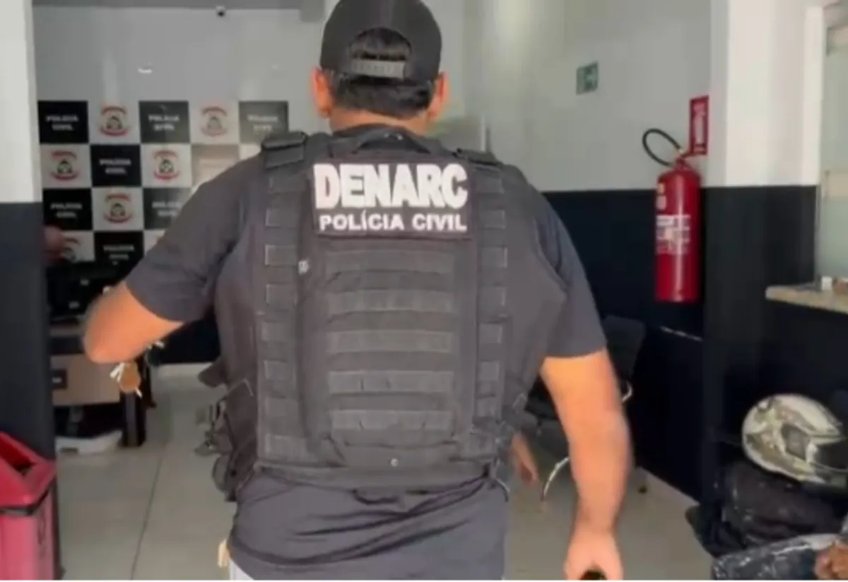 Mãos algemadas de forma sutil em frente a um edifício institucional, simbolizando prisão e justiça em caso de abuso infantil
