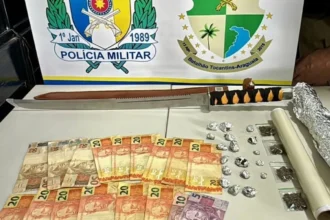 Policiais militares do Tocantins inspecionando drogas e armas apreendidas em operação em Buriti.
