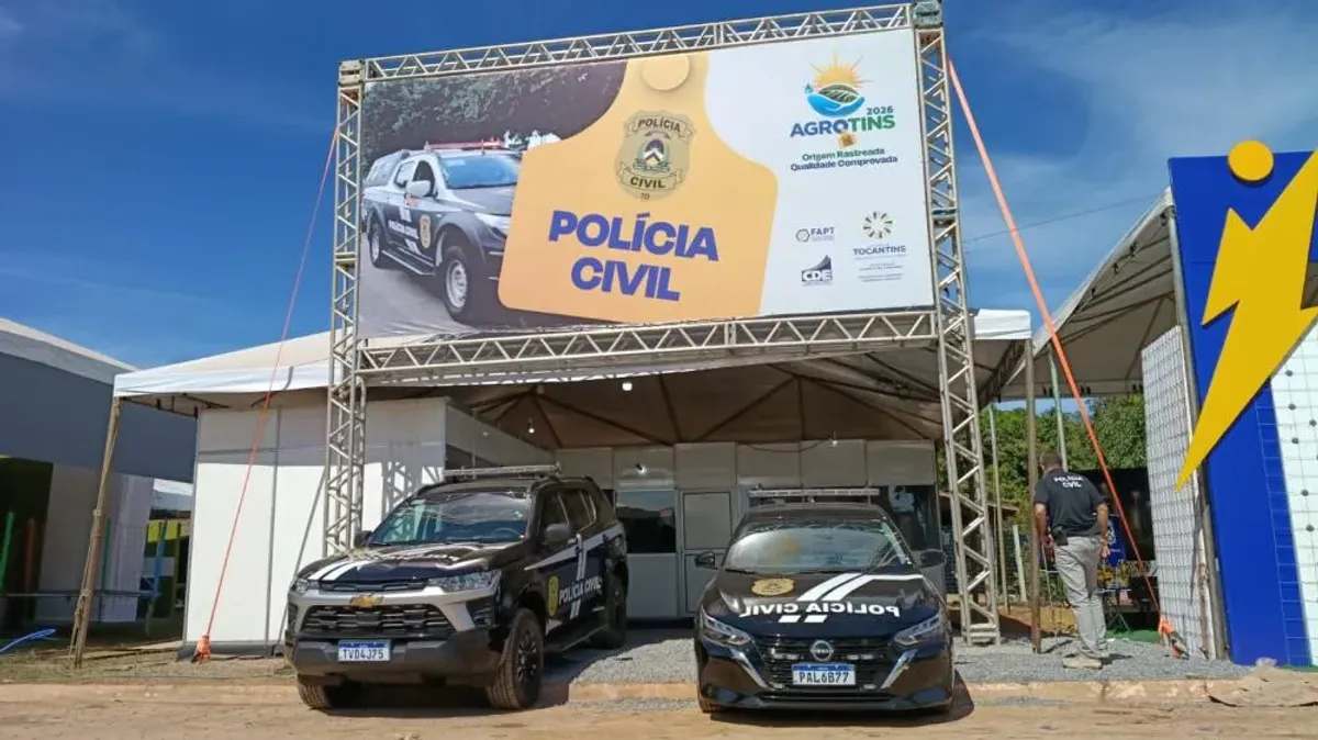 Policiais civis atendendo o público em estande durante a Agrotins 2026, oferecendo suporte e segurança.